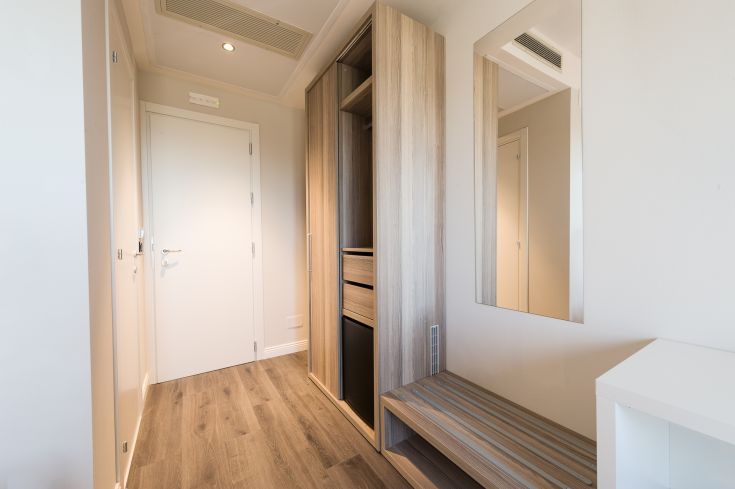 Un ingresso sobrio con armadi in legno e alcuni specchi, accogliente per gli ospiti.