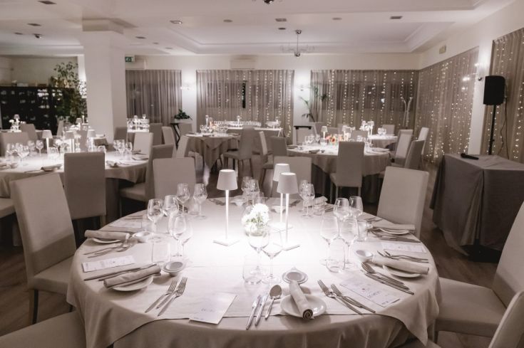 Ambiente di un ristorante con un'atmosfera accogliente, illuminato da candele e luci calde.