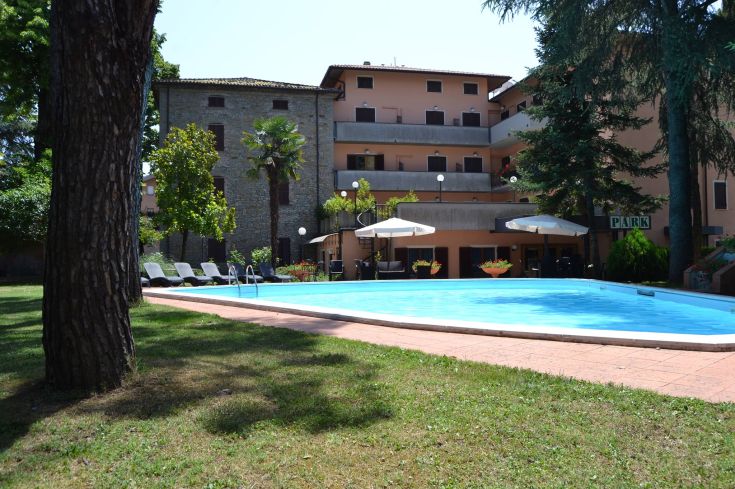 Hotel circondato da giardini, con piscina all'aperto, adatto per soggiorni turistici e professionali.