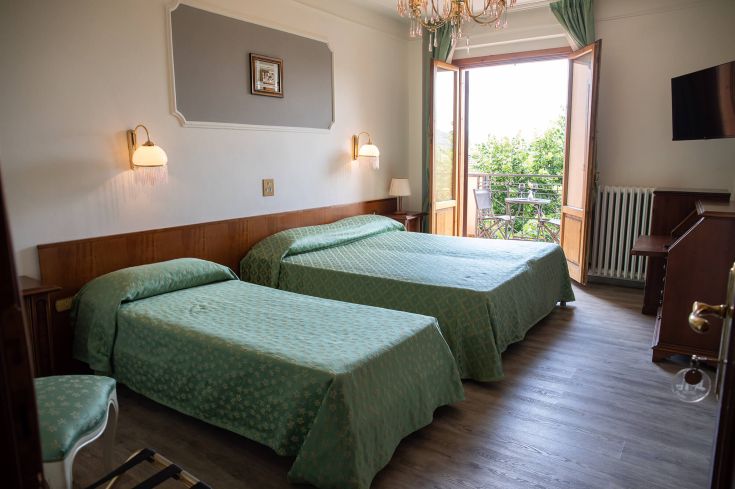 Camera confortevole con letti singoli e affaccio su un giardino. Spazio tranquillo e accogliente.