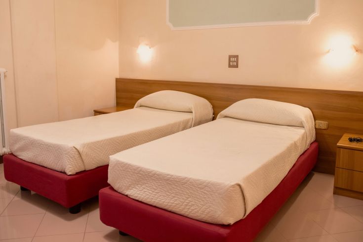 Una camera doppia con letti singoli, in un ambiente sereno e ben arredato.