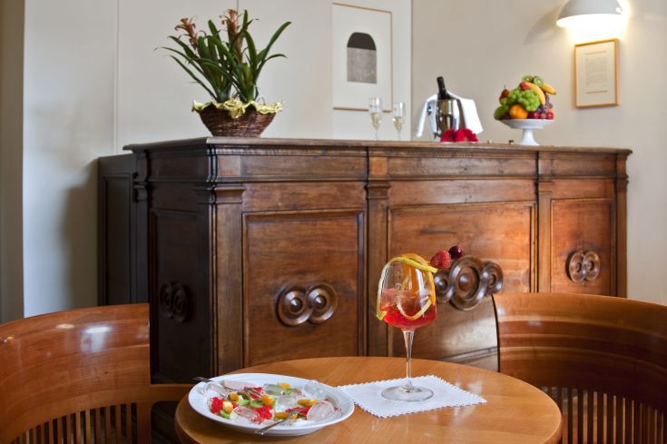 Un salotto con un tavolo che presenta un drink e alcuni dolci, arredato in stile classico.