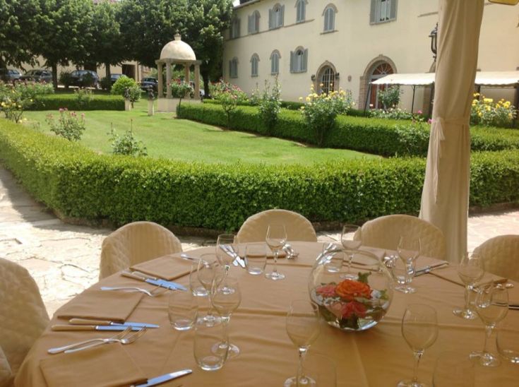 Un tavolo sistemato in un giardino ben tenuto, circondato da piante e fiori, perfetto per momenti all'aperto.