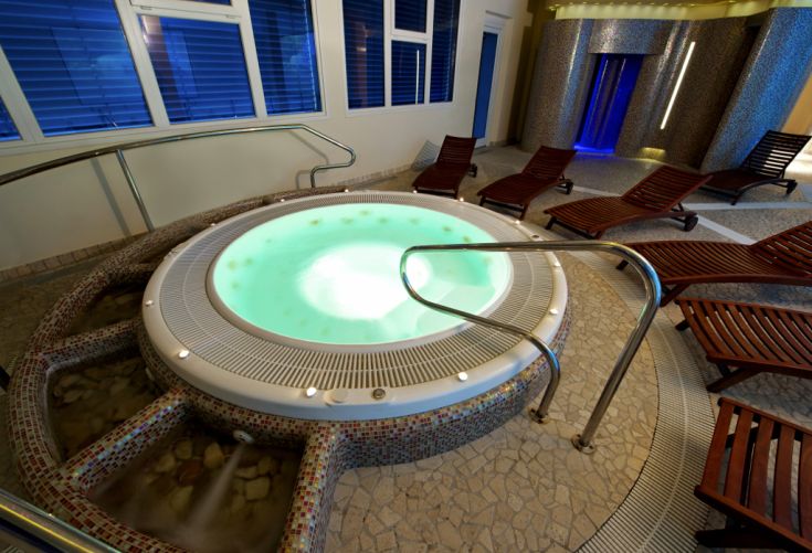 Vasca idromassaggio immersa in un ambiente confortevole e accogliente, perfetta per momenti di relax.