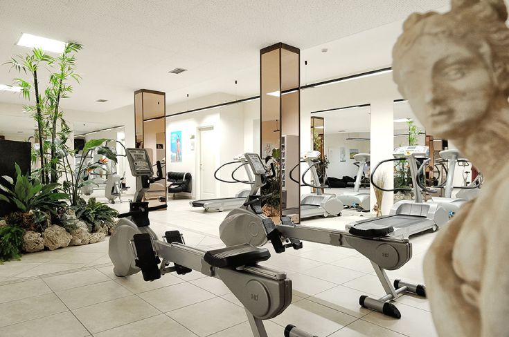 Spazio fitness attrezzato con macchinari moderni, situato in un ambiente ben curato e accogliente.