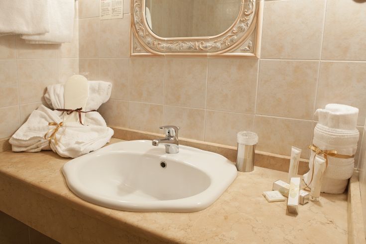 Lavabo semplice e pulito con asciugamani in un bagno tranquillo e ben illuminato.