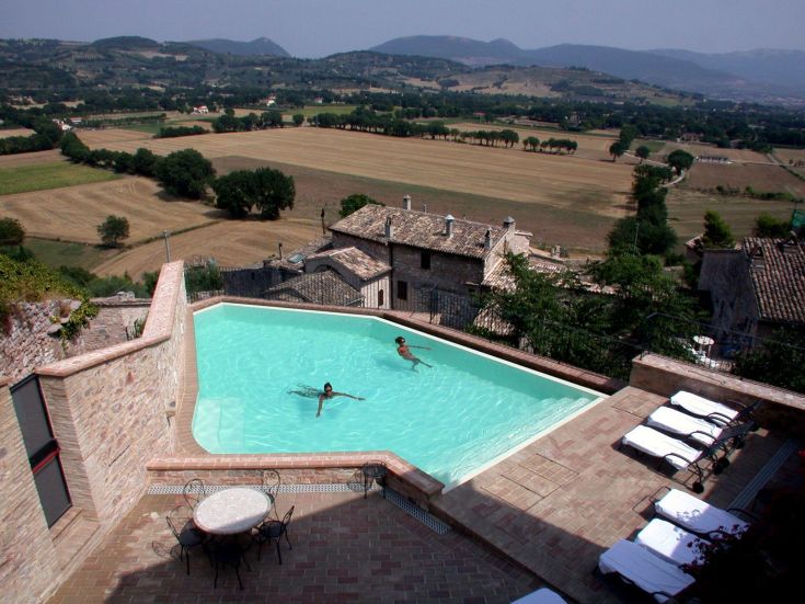 Momenti di relax in piscina circondata da campi verdi.