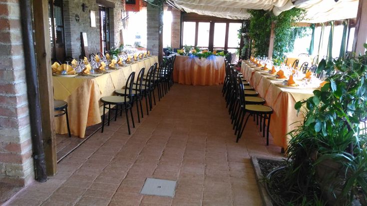 Un semplice allestimento di tavoli in un ambiente confortevole per un pranzo o cena.