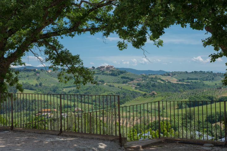 Un panorama sulla campagna umbra, con colline verdi e un cielo limpido.