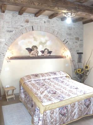 Camera matrimoniale con decorazioni semplici e soffitto in legno, spazio accogliente e con elementi tradizionali.