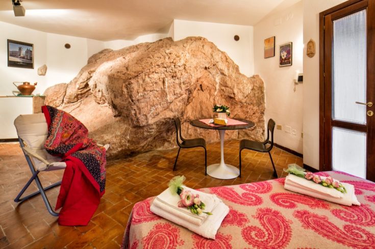 Interno di un palazzo caratterizzato da una parete in pietra e arredi rustici, adatto a momenti di tranquillità.