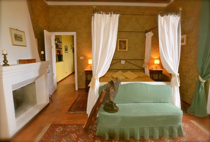 Camera semplice all'interno di un palazzo, arredata con mobili tradizionali che conferiscono un'atmosfera rilassata.