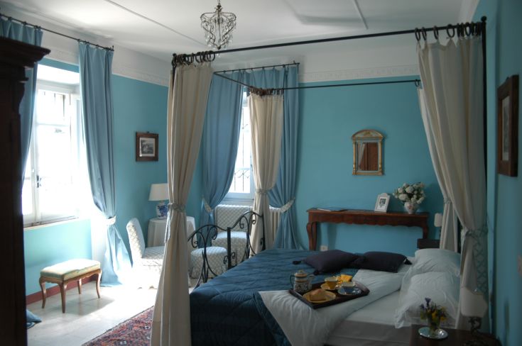 Camera tranquilla con letto a baldacchino. Presenta decorazioni tradizionali e un ambiente confortevole per il relax.