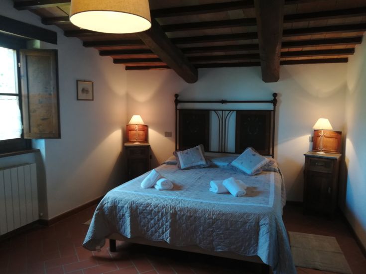 Chambre simple avec un lit double et des éléments en bois, parfaite pour un séjour tranquille.