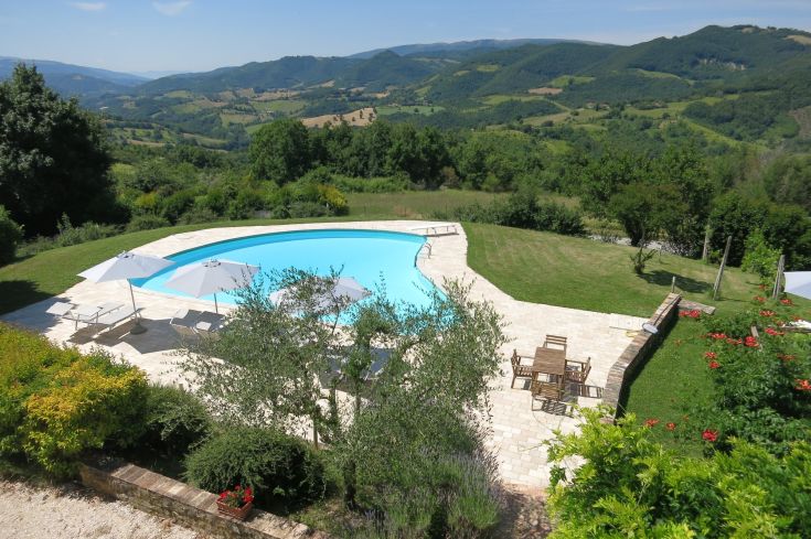 Une piscine naturelle entourée de collines et de nature, située dans un cadre serein et panoramique.