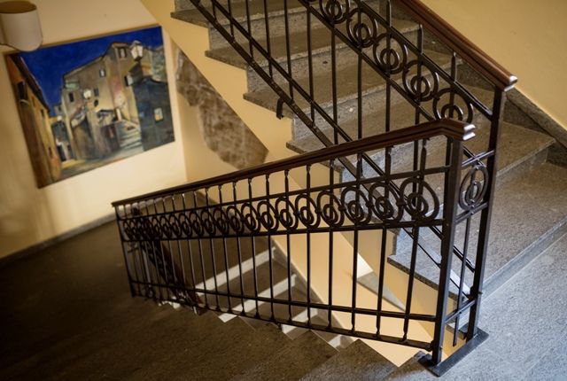 Détail d'un escalier avec une rampe simple et une décoration accrochée au mur.
