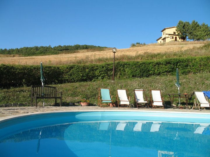 Una piscina circondata da alberi e natura, in una proprietà tipica dell'Umbria. Un luogo tranquillo per il relax.