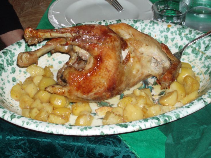 Un piatto di anatra arrosto accompagnato da patate, adatto per occasioni particolari.