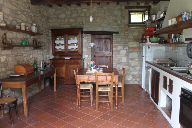 Simple stone kitchen with classic furniture elements in a cozy atmosphere.