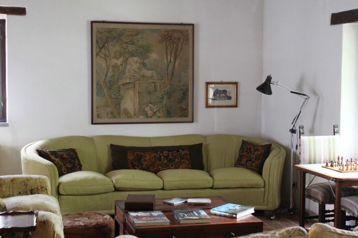A simple living room with a green sofa and wall decorations.