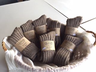 Wool socks arranged in a wicker basket, perfect for everyday comfort. Suitable for all seasons.