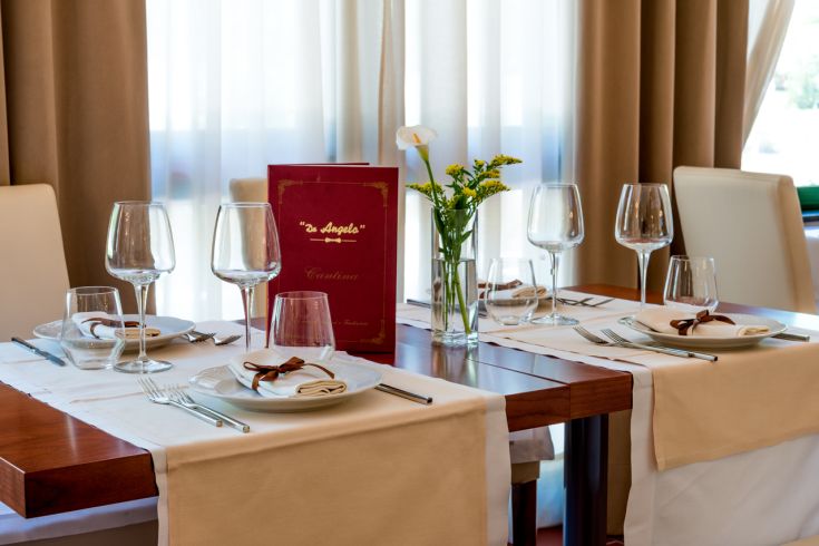 Une table bien organisée avec un linge soigné et des décorations florales à l'intérieur d'un restaurant.