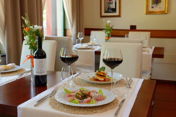 Un restaurant simple avec des tables soigneusement dressées, des plats bien présentés et une sélection de vins. Idéal pour un repas tranquille.