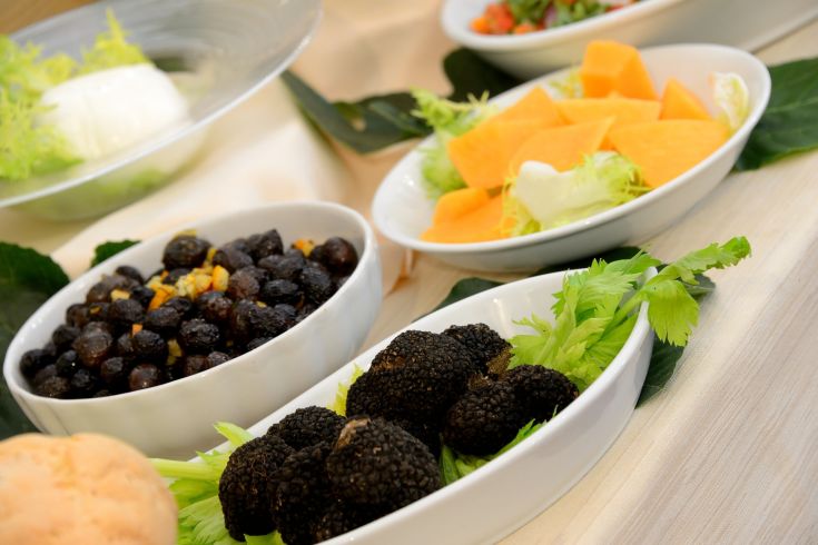 Une variété de plats frais et colorés, présentés avec des légumes et des fruits de saison.