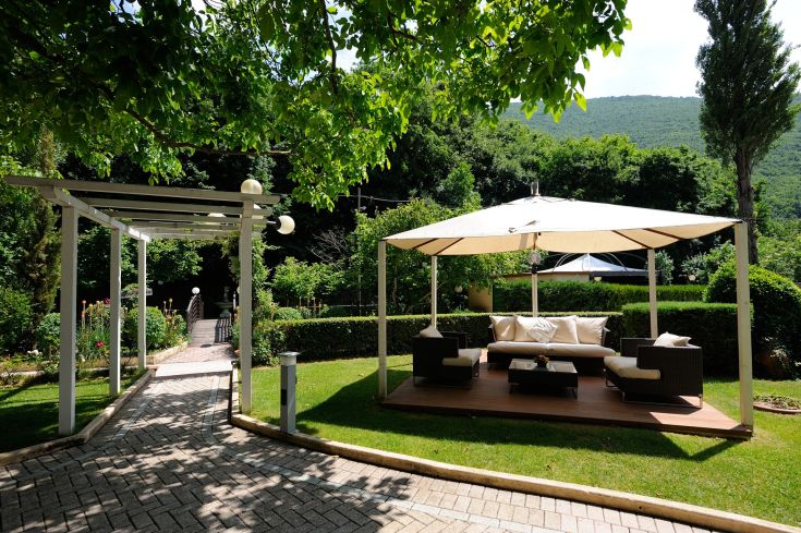 Une zone de détente extérieure sereine dans un jardin bien entretenu, avec des sièges confortables.