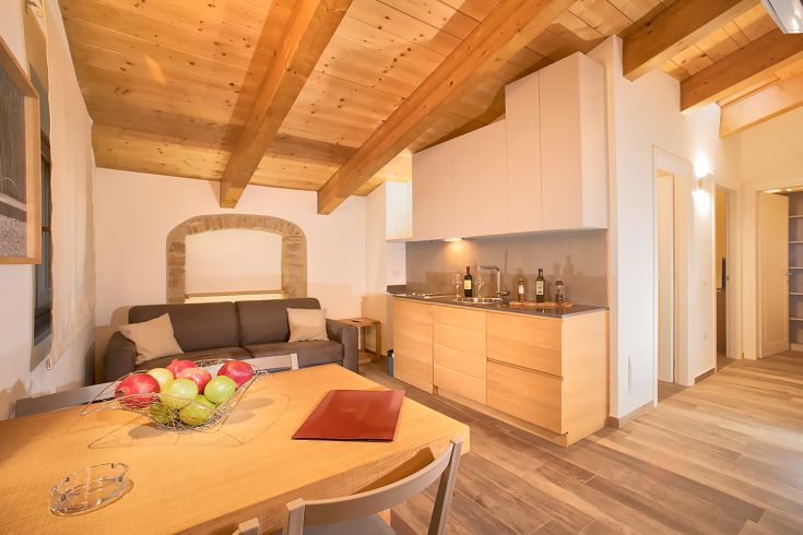 Intérieur d'un appartement moderne avec des plafonds en bois et une cuisine entièrement équipée.