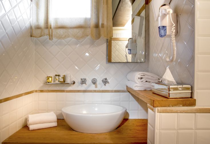 Une salle de bain simple et accueillante, avec une baignoire blanche et des éléments en bois.