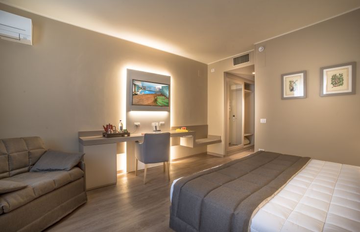 Chambre accueillante de style contemporain, avec un éclairage doux et des meubles fonctionnels.