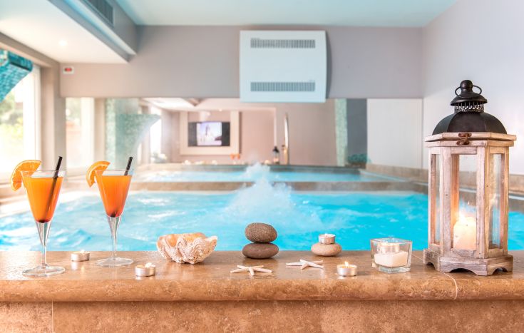 Une zone tranquille avec des boissons fraîches et une piscine intérieure au design simple.