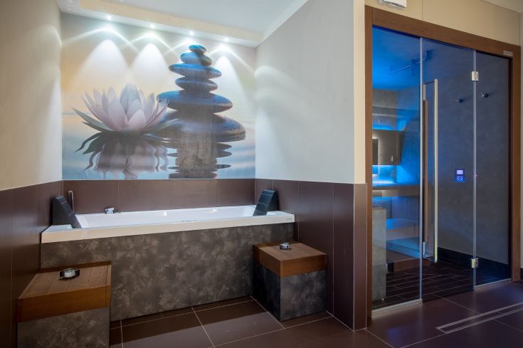 Salle de bain spacieuse avec jacuzzi, sauna et décor zen, idéale pour des moments de détente.