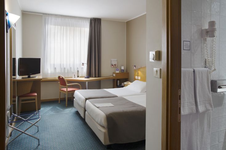 Simple room with a double bed, desk, and television. Great space for peaceful stays.