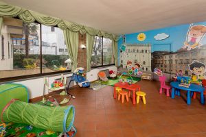 Ein geräumiger Spielraum für Kinder, eingerichtet mit hellen Farben und verschiedenen Spielzeugen.
