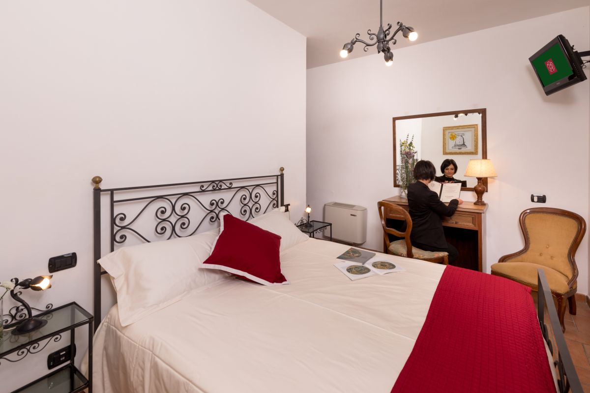 Einfache Schlafzimmer mit bequemen Betten und einem Arbeitsbereich, ideal zum Entspannen und für Arbeitstätigkeiten.