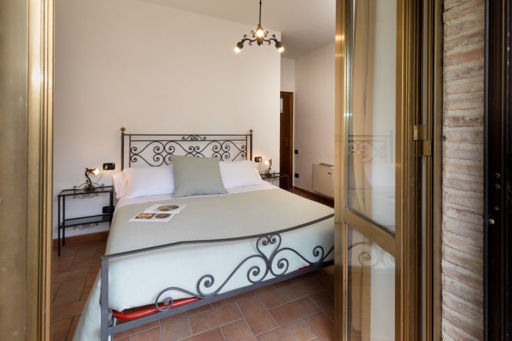 Ein warmes und einladendes Zimmer mit einem Schmiedeeisenbett und modernen Möbeln.