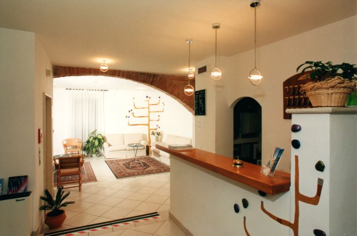 Hall accogliente dell'hotel Tre Ceri, caratterizzata da dettagli semplici e una zona per il relax.