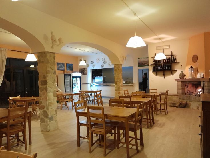 A cozy restaurant with wooden tables and a fireplace. The atmosphere is warm and inviting.