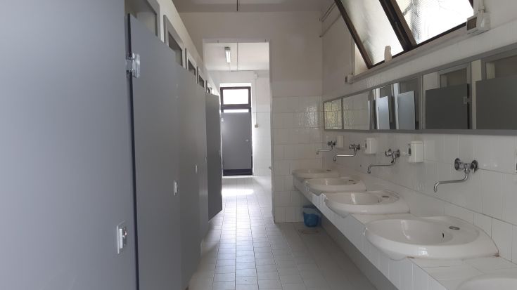Spacious and tidy public restrooms, equipped with sinks and stalls for enhanced privacy.
