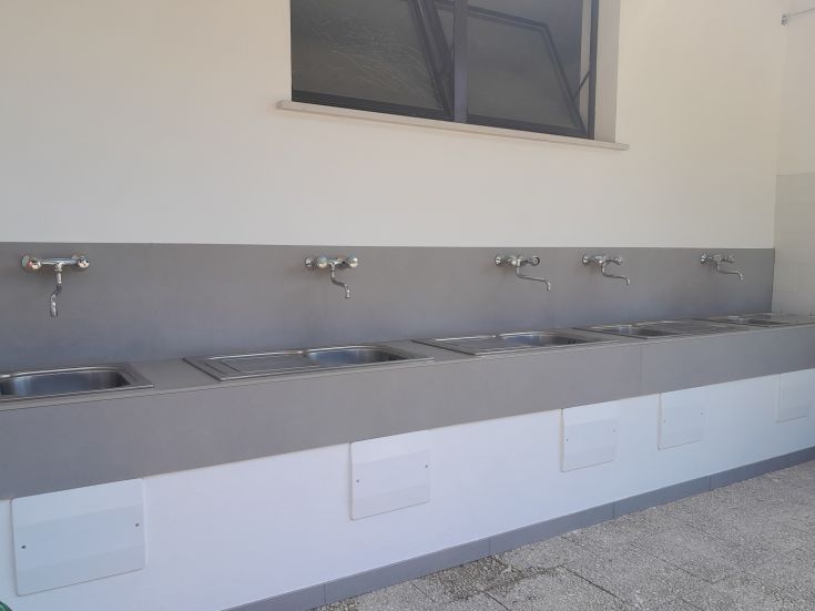 Laundry area with stainless steel sinks, designed to be functional and tidy.