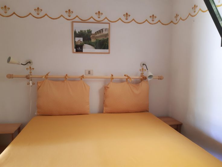 Cozy room with orange beds and simple decorations, perfect for a peaceful stay.