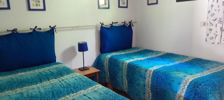 Cozy room with single beds and blue and white tones, perfect for a serene stay.