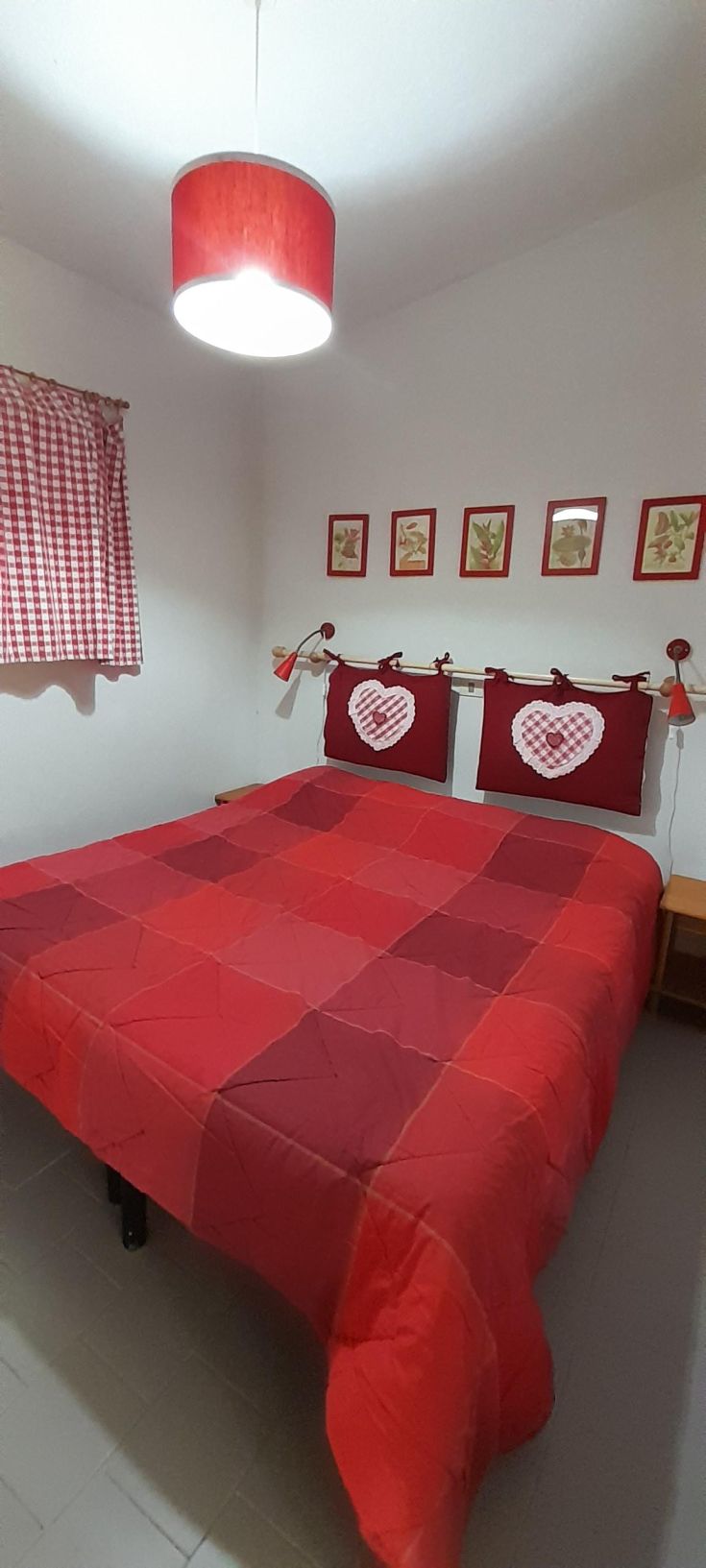 Cozy room with red furniture, comfortable beds, and soft lighting.