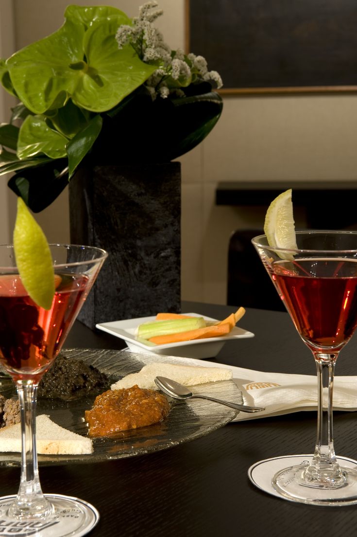 Des cocktails présentés avec différents amuse-bouches dans un cadre sobre et raffiné.