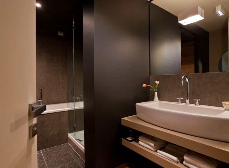 Salle de bain moderne avec un lavabo et une douche, aménagée de manière simple et fonctionnelle.