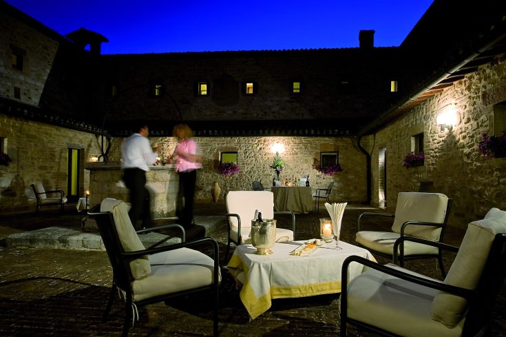 Ambiance sobre avec des tables dressées et des fleurs fraîches, dans un ancien monastère rénové.