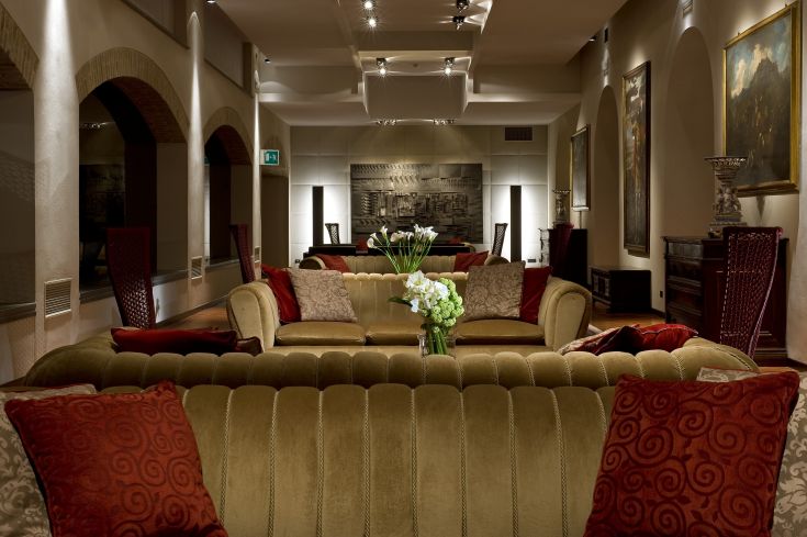 Salon confortable avec des canapés et des décorations dans un bâtiment rénové, aux tons chaleureux et à l'atmosphère accueillante.