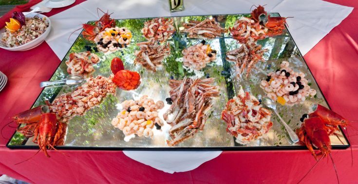 Un buffet de fruits de mer avec un assortiment de crevettes et de homards disposés simplement sur un grand plateau.